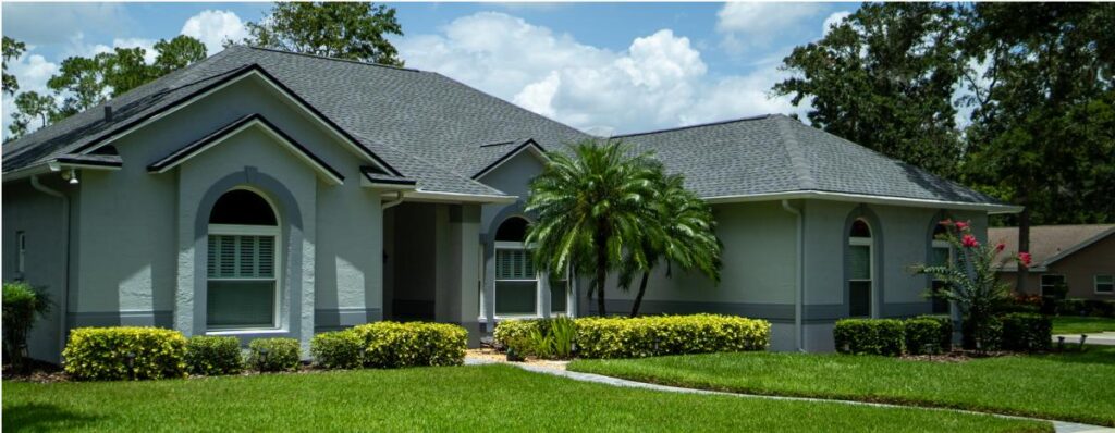 Front view of a house with a manicured lawn and landscaped gardens in a residential neighborhood