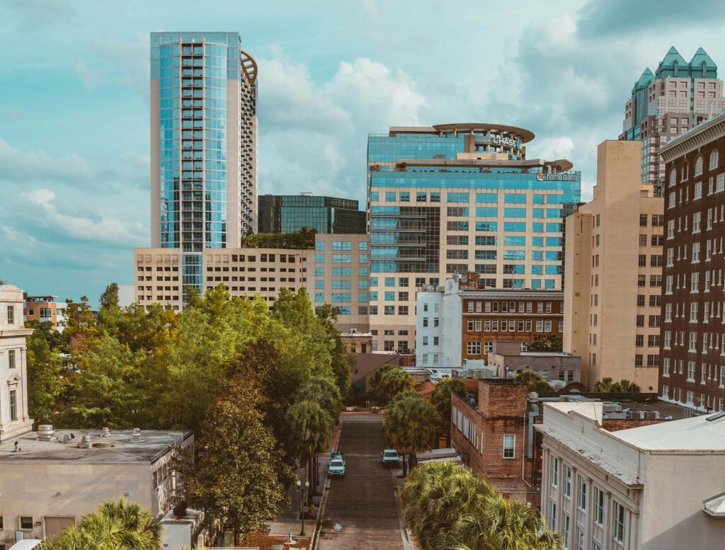 View of urban skyline with several tall modern buildings surrounded by trees