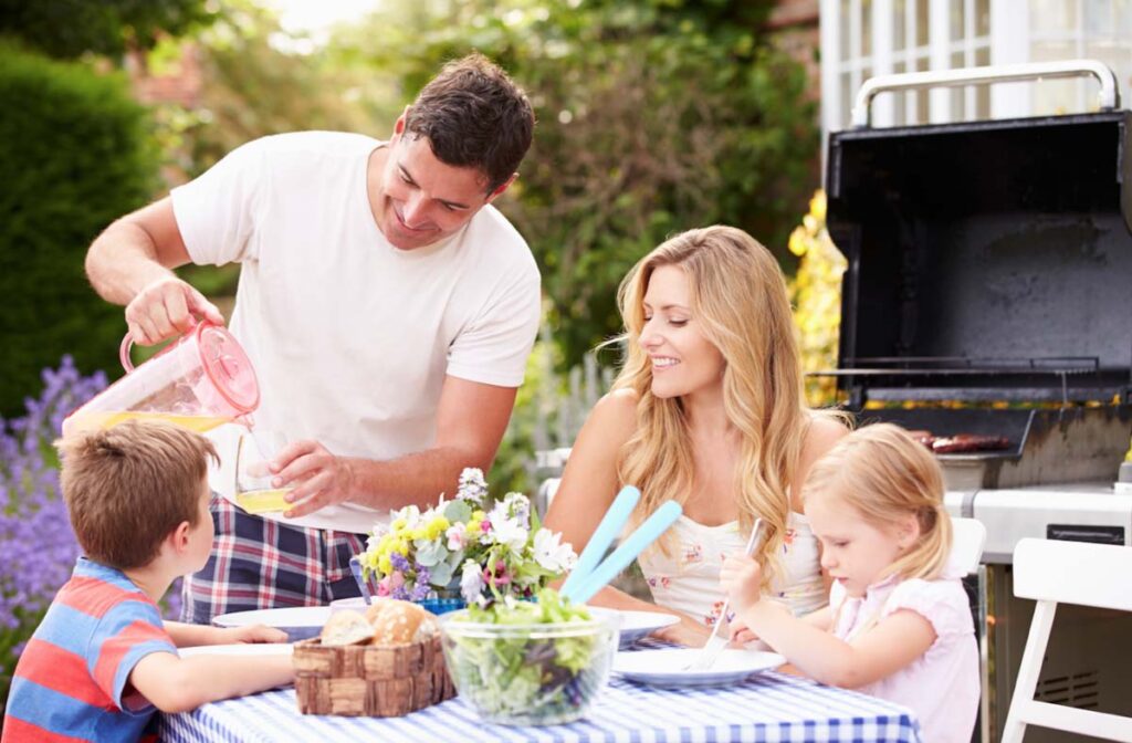 Family of four enjoying a meal outdoors in the garden